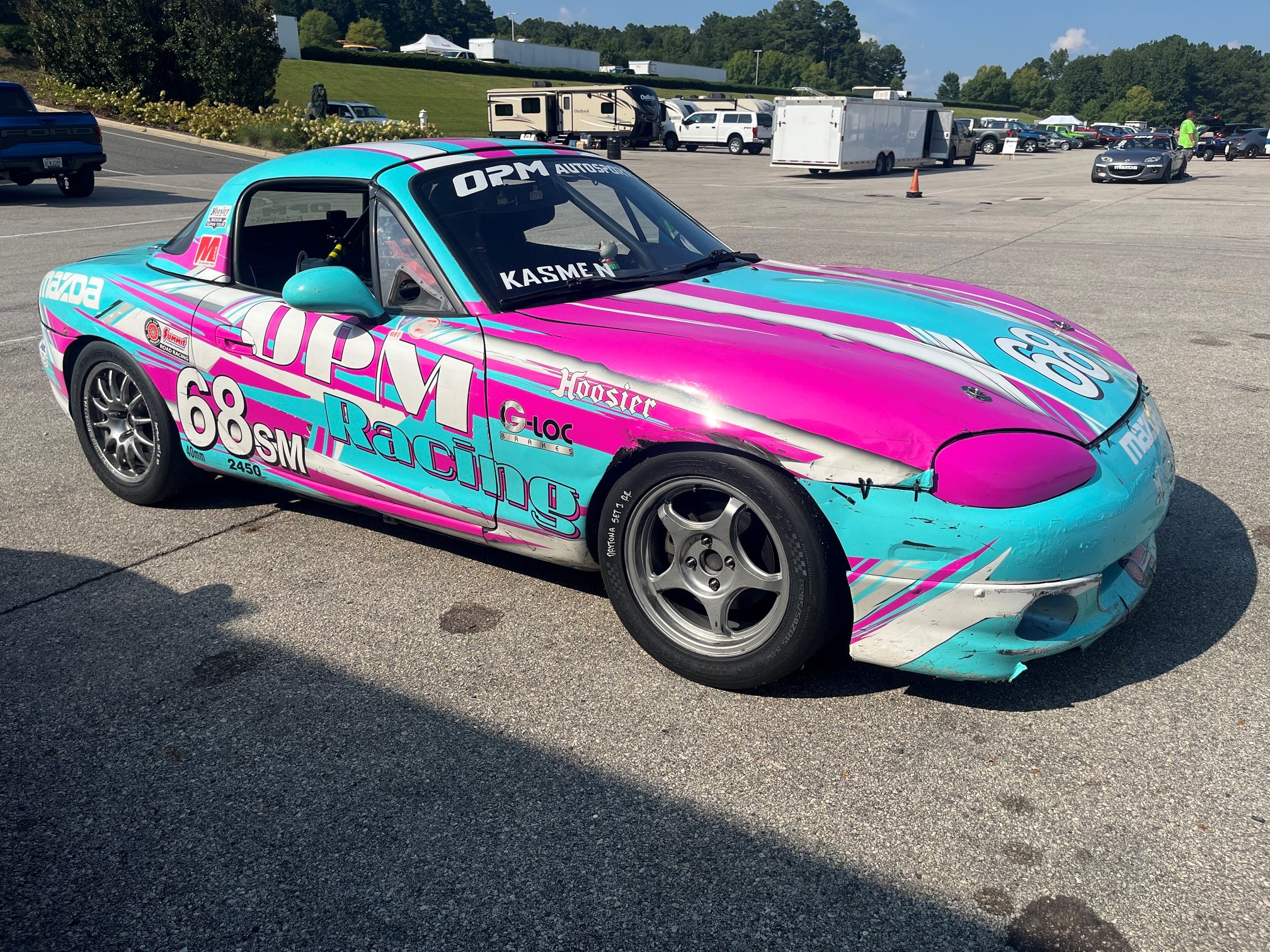 The No. 68 OPM Racing Spec Miata parked in a lot before an event
